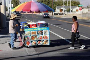El vendedor ambulante Luis Serrano atiende a los clientes en el Historic Westside de Las Vegas, ...