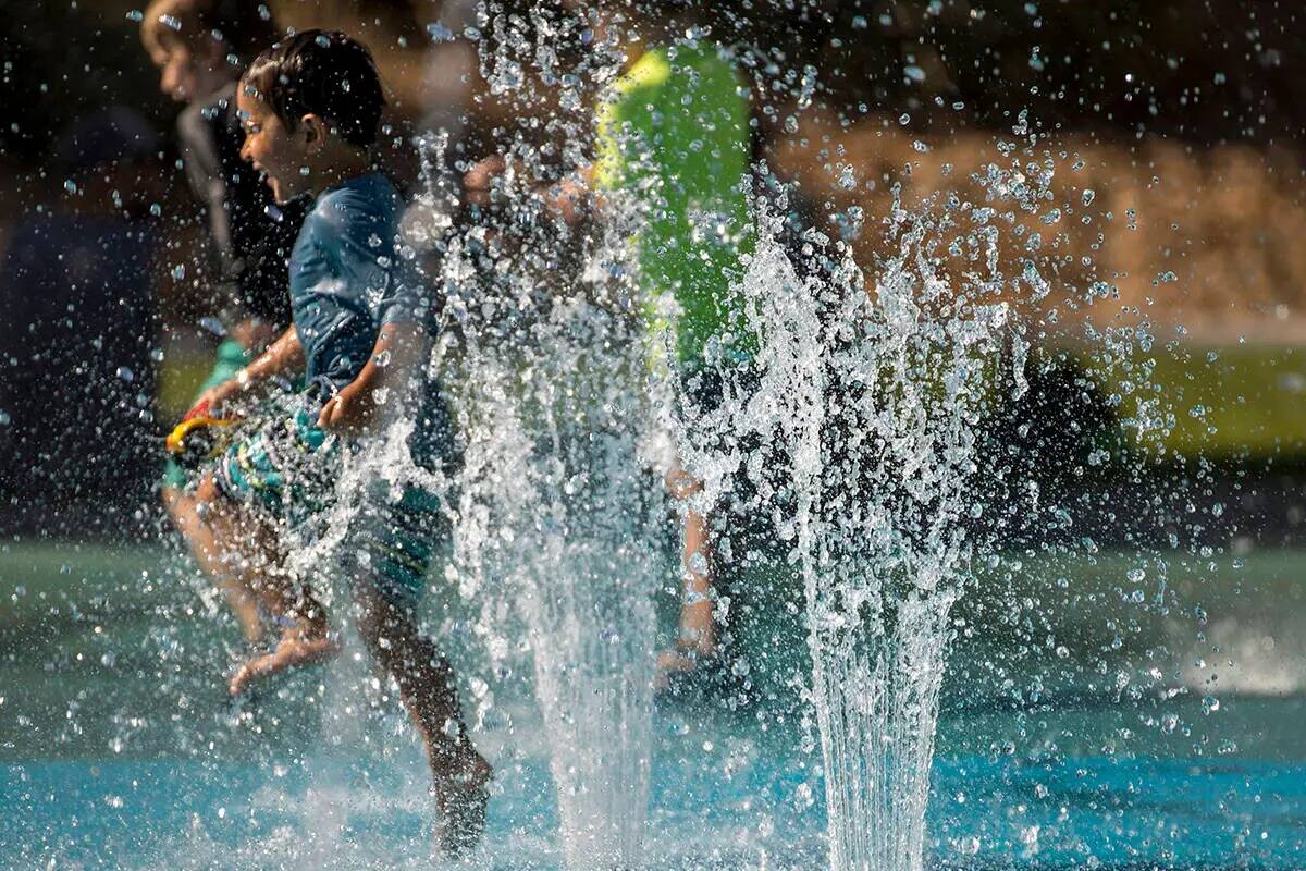 Leo Reyes, de 3 años, corre por las fuentes de agua mientras se mantiene fresco en el chapotea ...