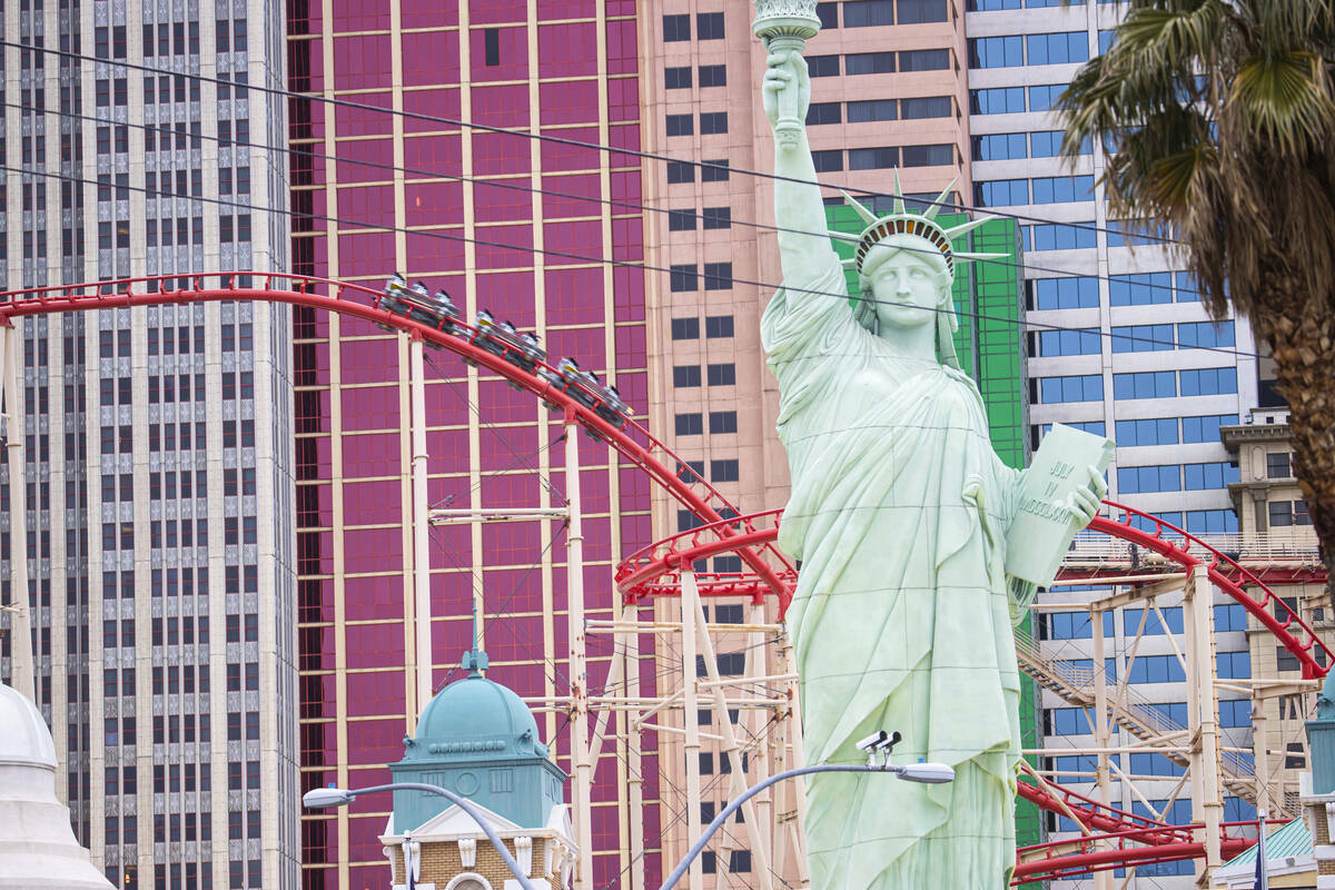 Personas montan en la Big Apple Coaster en New York-New York a lo largo del Strip de Las Vegas, ...