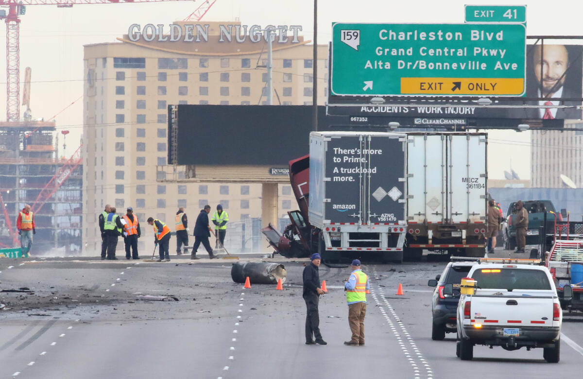 Trabajadores limpian los escombros después de un accidente automovilístico fatal en el que mu ...