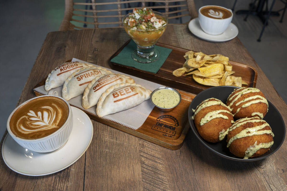 Una variedad de empanadas variadas, bolas de papa, ceviche de camaron con plátanos y café en ...