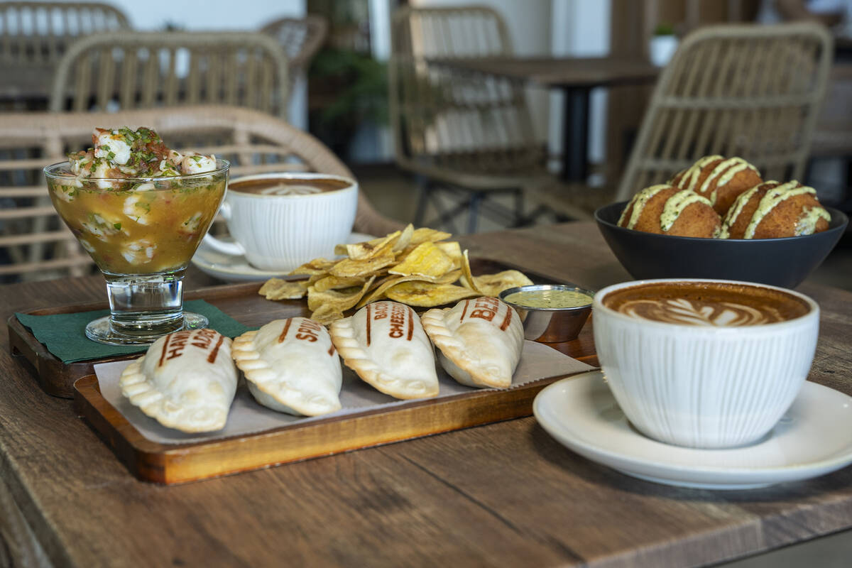 Una variedad de empanadas variadas, bolas de papa, ceviche de camaron con plátanos y café en ...