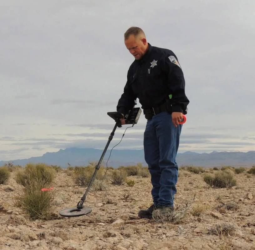 El guarda de caza Michael Geist busca pruebas usando un detector de metales cerca de un sitio d ...