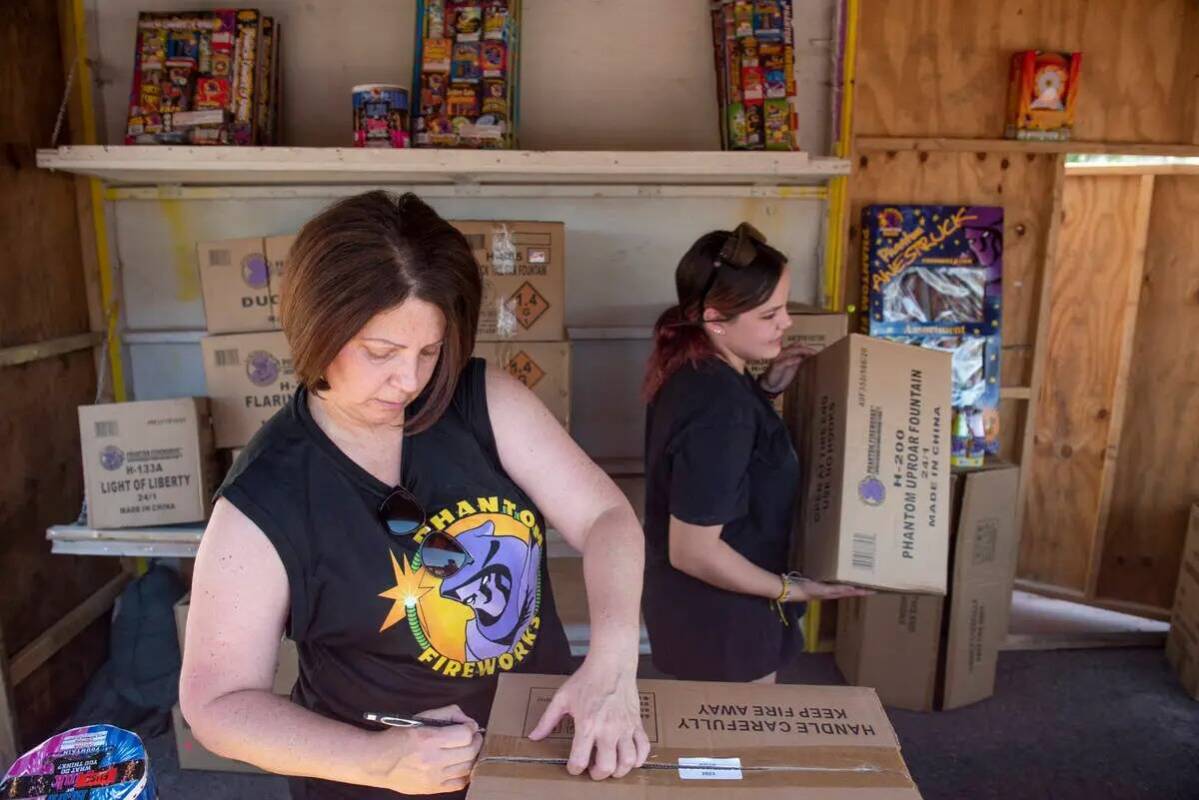 Shellie Moskos, izquierda, y Hannah Dockery desempaquetan y organizan cajas de fuegos artificia ...