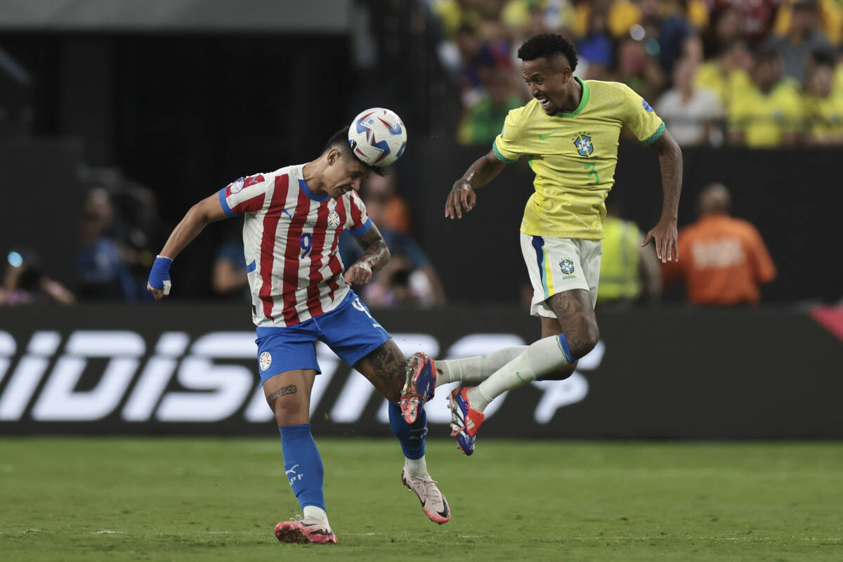 Adam Bareiro de Paraguay cabecea el balón desafiado por Eder Militao de Brasil durante un part ...