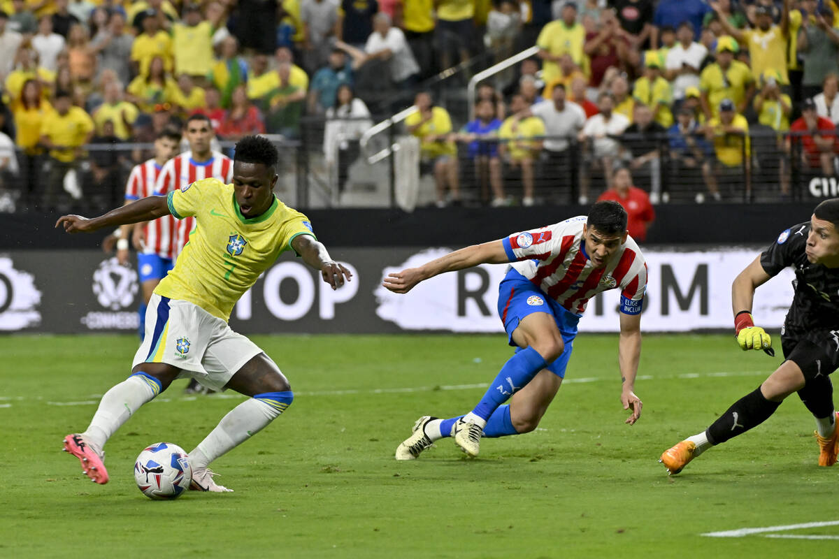 El brasileño Vinicius Junior, izquierda, anota el primer gol de su equipo contra Paraguay dura ...