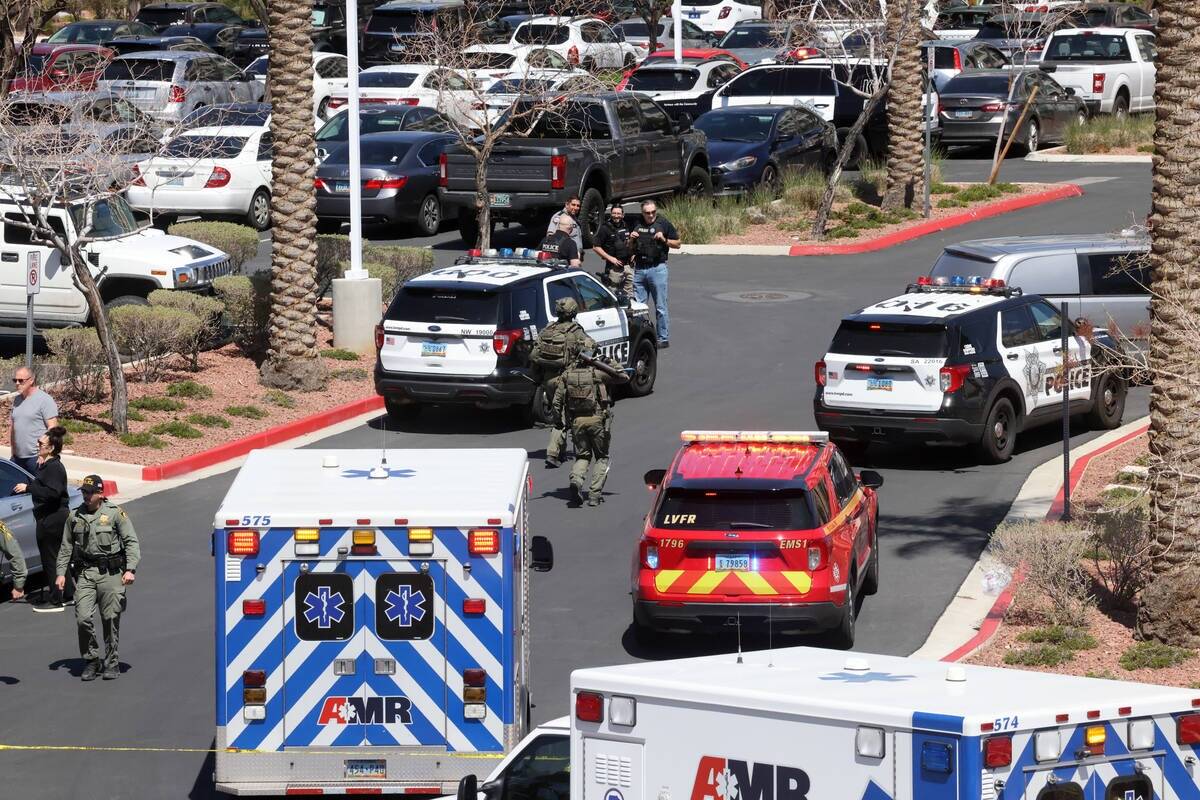 Policías de Las Vegas con un martillo y una palanca corren hacia el edificio del City National ...