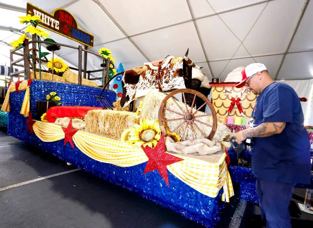 Ricardo Sandoval, un voluntario, decora la carroza "Red White and Rodeo", que se presentará en ...