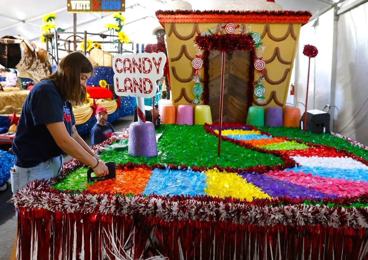 Jordyn Doyle, izquierda, y Dave Bailey, ambos voluntarios, decoran la carroza "Visions of Candy ...