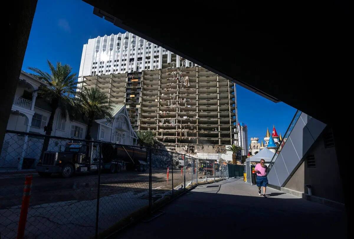 Un peatón camina bajo un puente mientras continúa la demolición del Tropicana en preparació ...