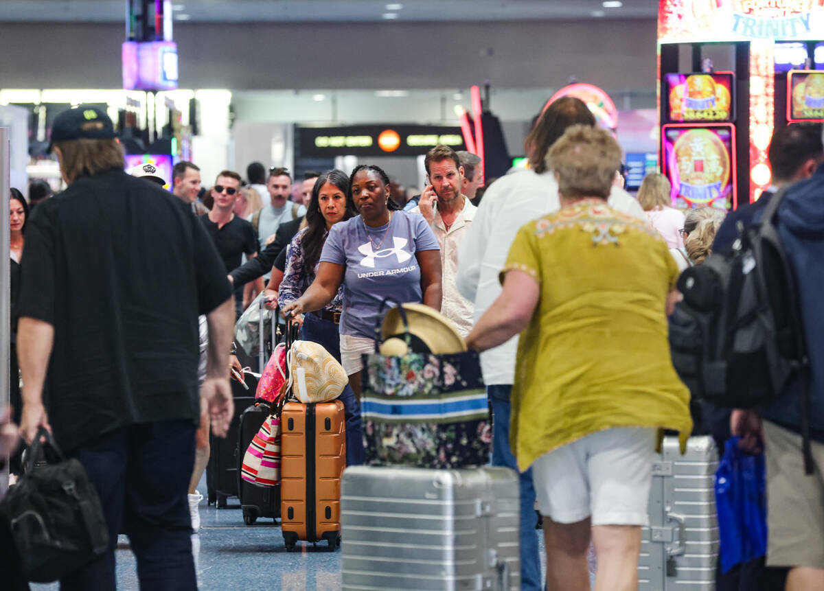 Viajeros pasan por la zona de reclamo de equipaje del Aeropuerto Internacional Harry Reid, en L ...