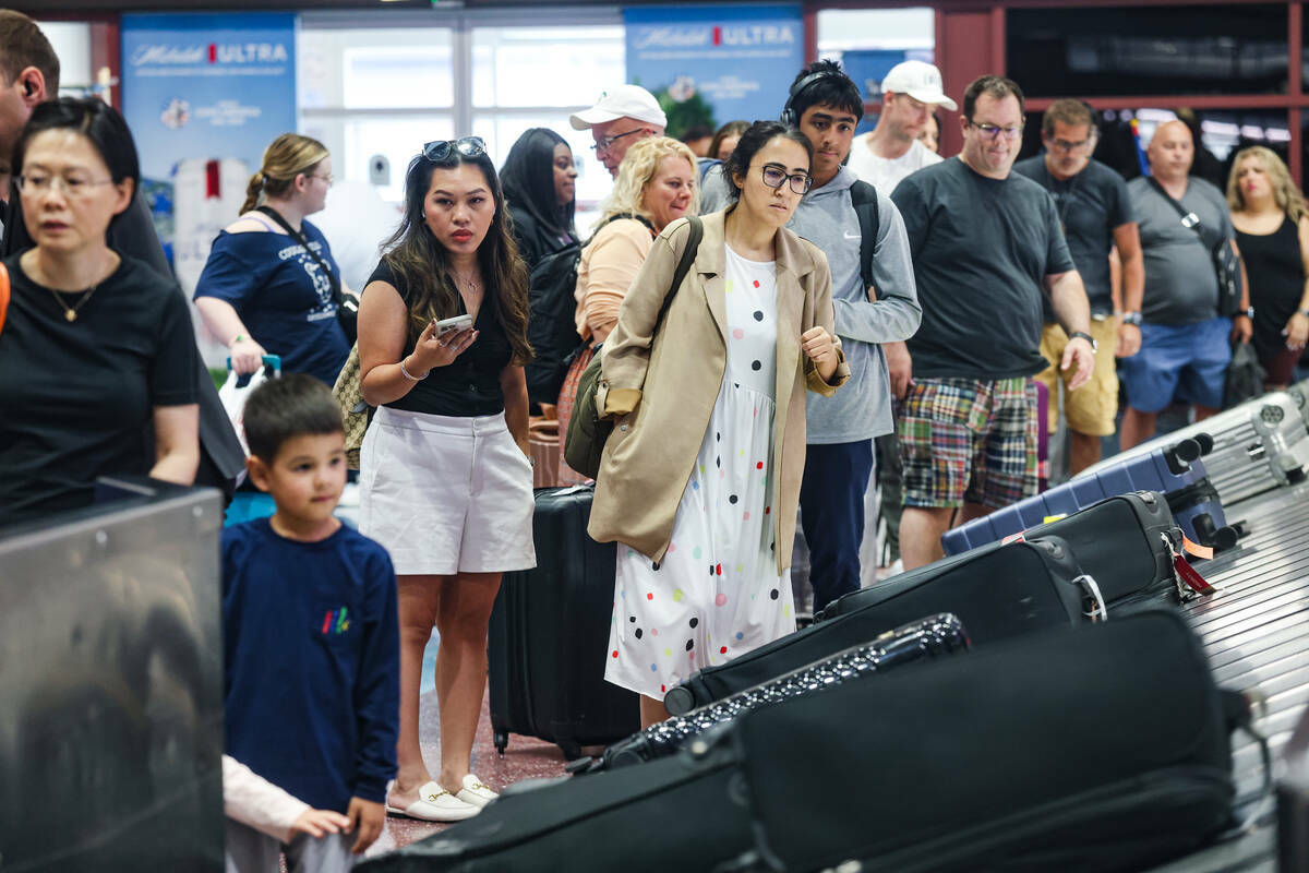 Viajeros esperan su equipaje en el área de reclamo de equipaje del Aeropuerto Internacional Ha ...