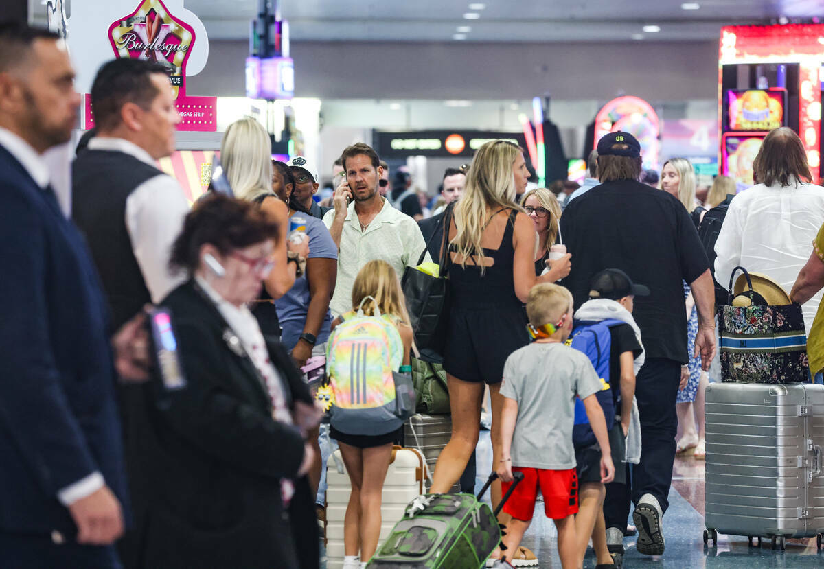 Viajeros pasan por la zona de reclamo de equipaje del Aeropuerto Internacional Harry Reid, en L ...