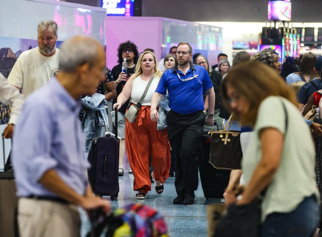 Viajeros pasan por la zona de reclamo de equipaje del Aeropuerto Internacional Harry Reid, en L ...