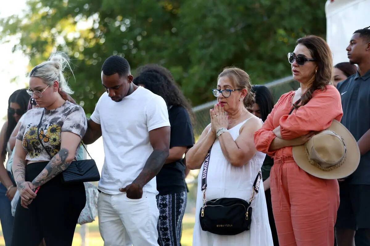 Los seres queridos de Alondra Rivera rezan durante una vigilia en Winterwood Park el miércoles ...