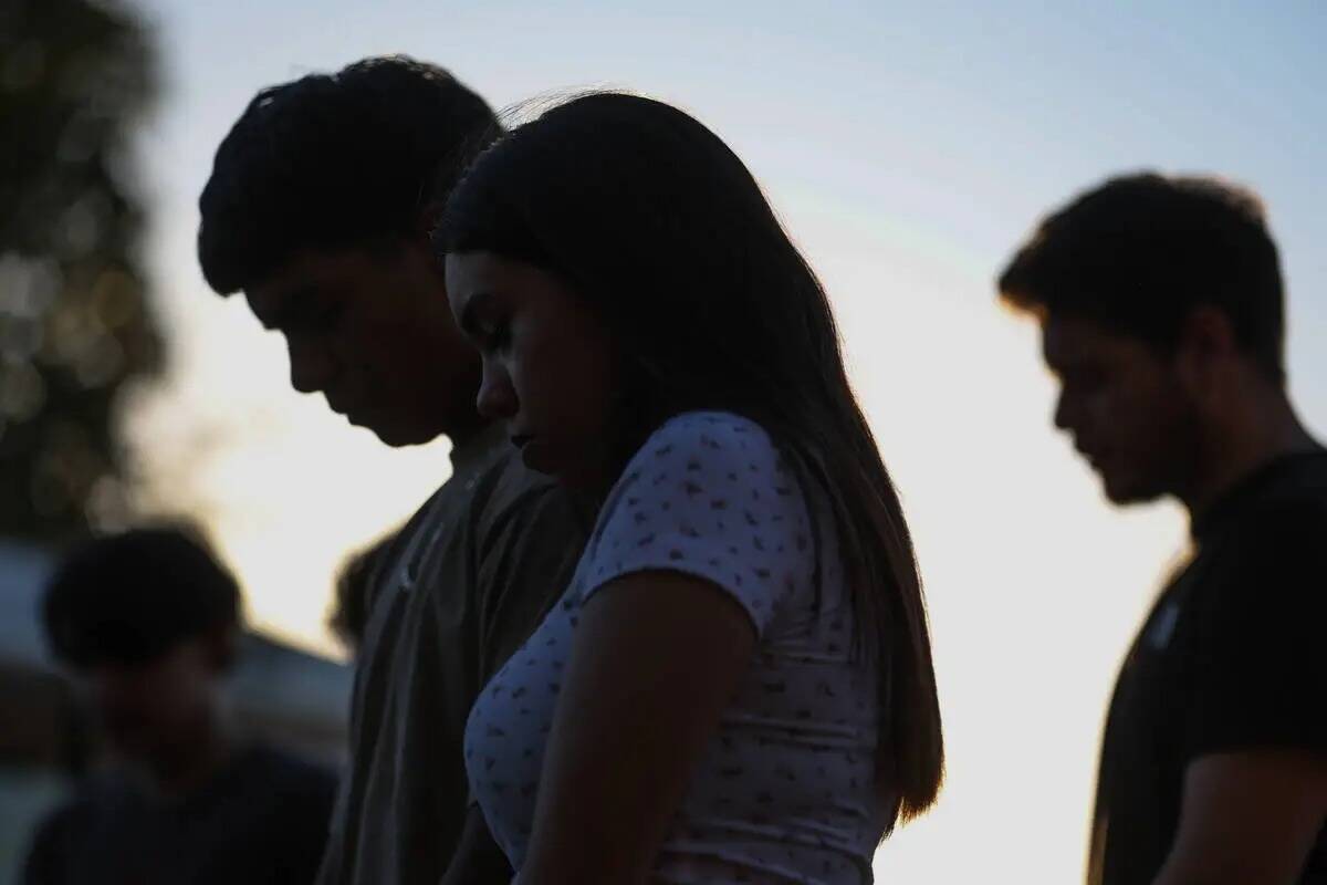 Los seres queridos de Alondra Rivera rezan durante una vigilia en Winterwood Park el miércoles ...