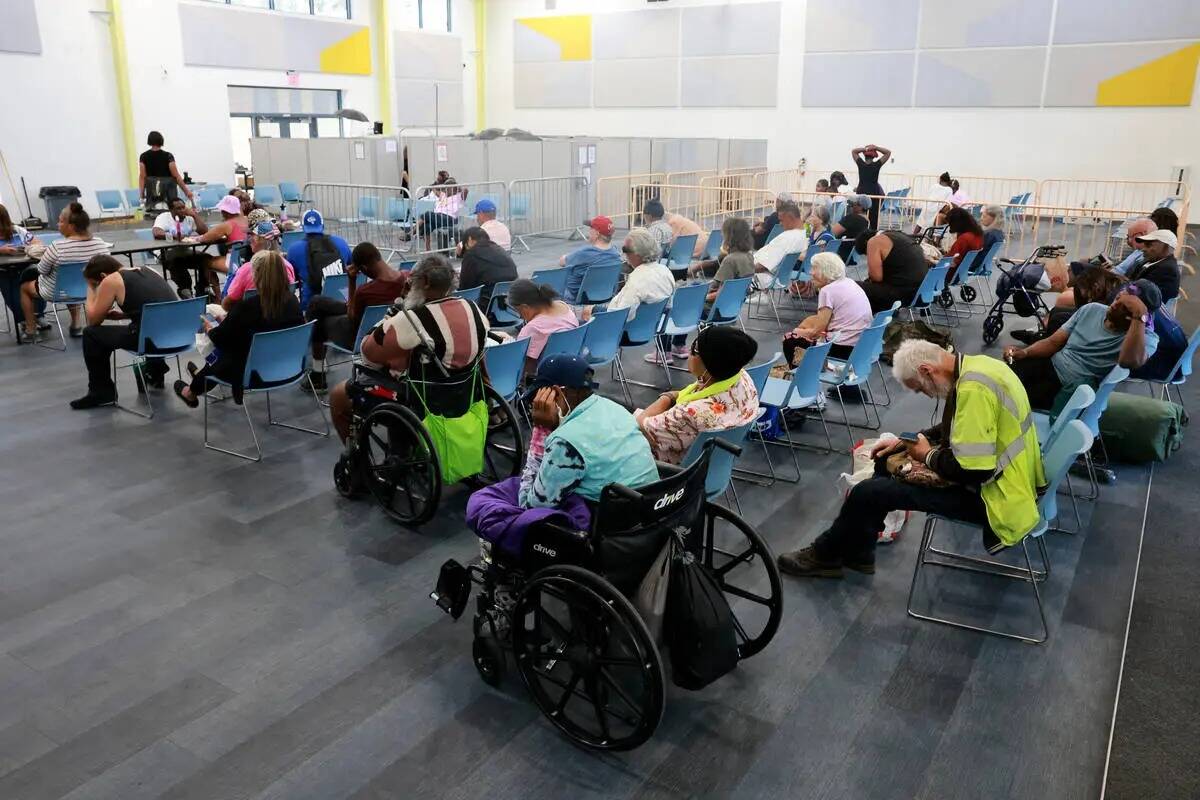 Personas combaten el calor en una estación de enfriamiento en Courtyard Homeless Resource Cent ...