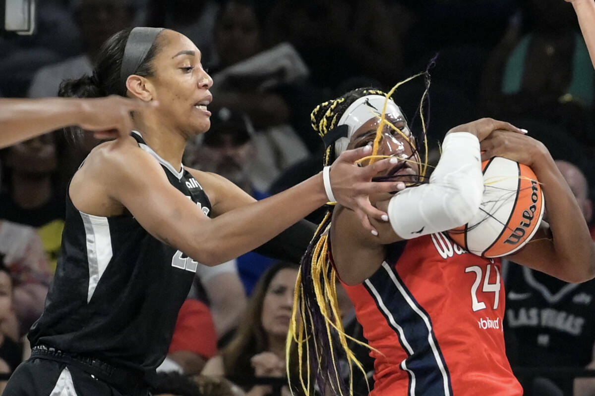 La centro de Las Vegas Aces A'ja Wilson (22) defiende frente a la alero de las Washington Mysti ...