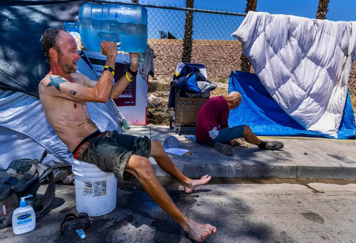 Un desamparado, Milton John Scott III, se echa una jarra de agua en la cabeza para escapar del ...