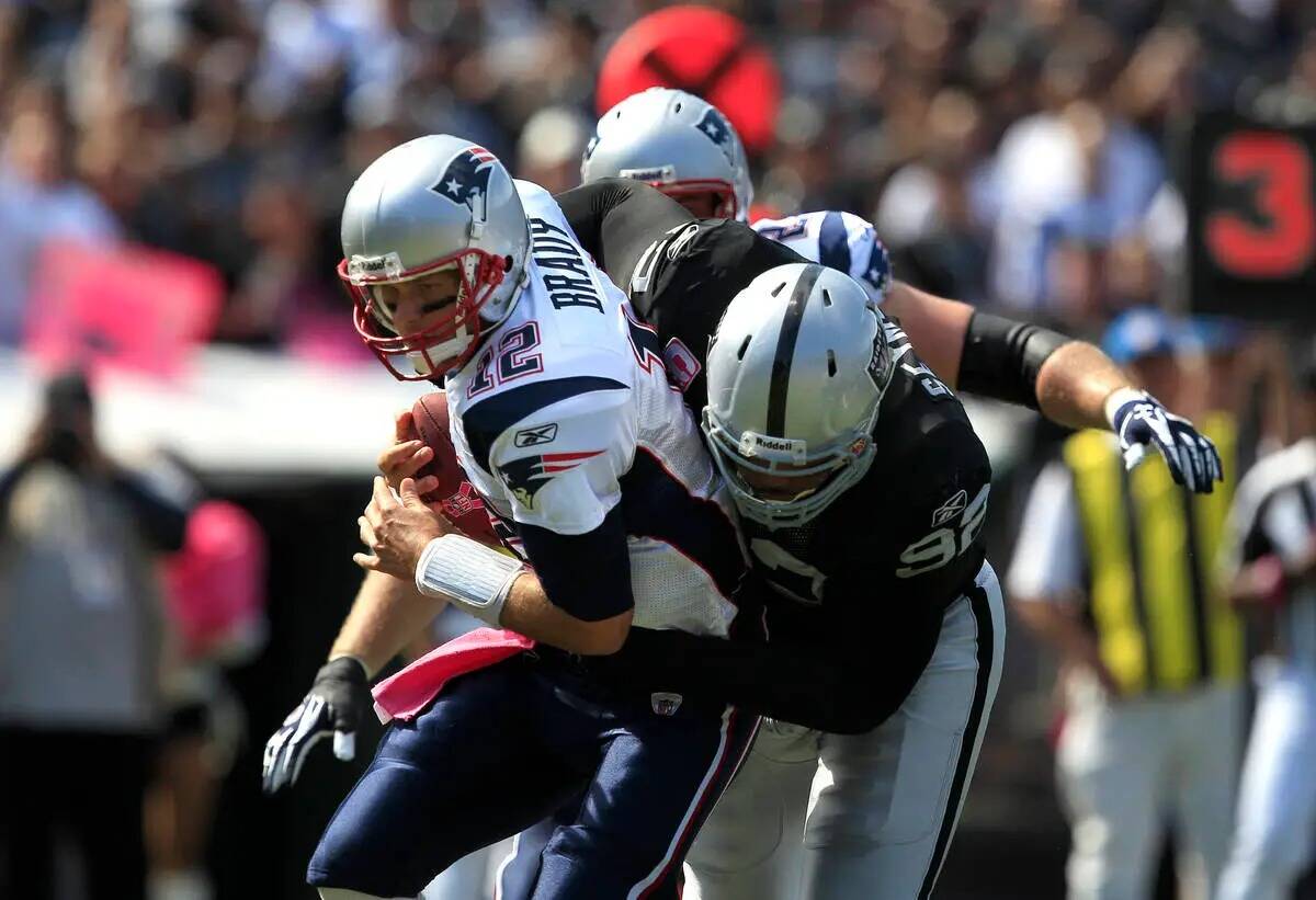 El defensive tackle de los Oakland Raiders Richard Seymour (92) taclea al quarterback de los Ne ...