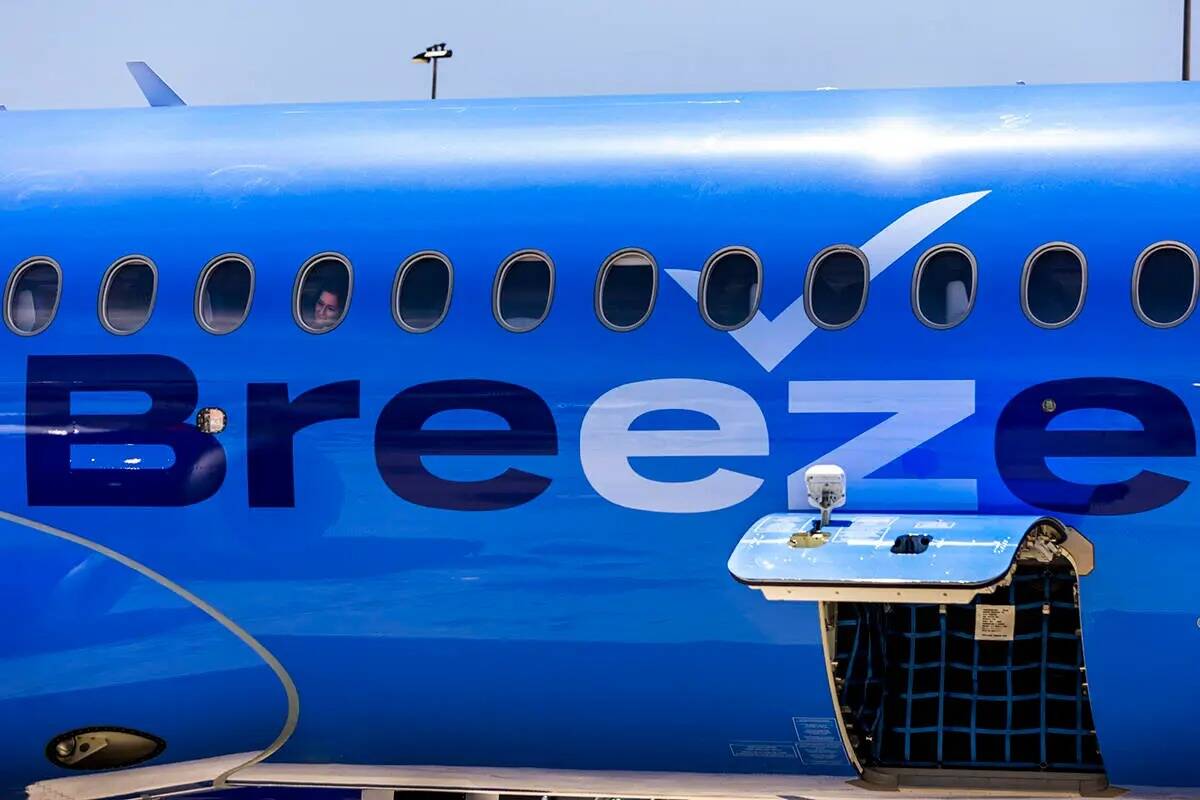 Un pasajero de Breeze Airways observa por la ventanilla la llegada de su vuelo inaugural a la p ...