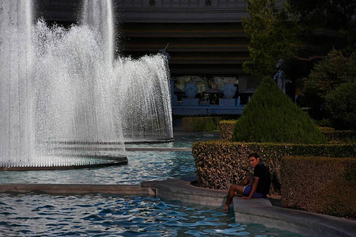 Una persona se refresca en una fuente del Caesars Palace, junto al Strip de Las Vegas, el domin ...