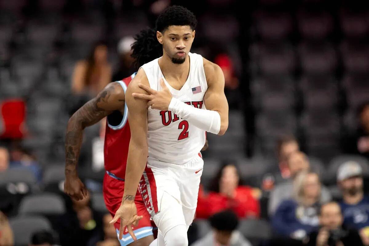 El escolta de los UNLV Rebels Justin Webster (2) celebra después de anotar un triple durante l ...