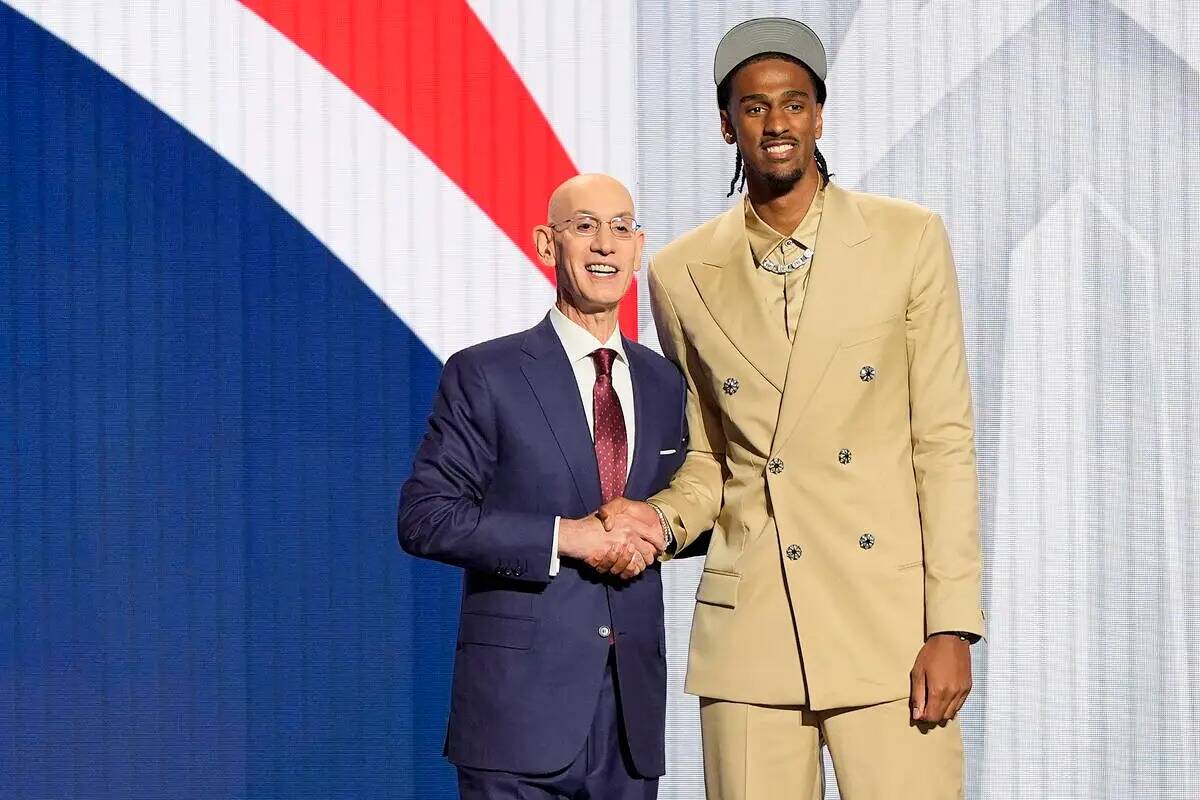 Alex Sarr, a la derecha, posa para una foto con el comisionado de la NBA Adam Silver después d ...