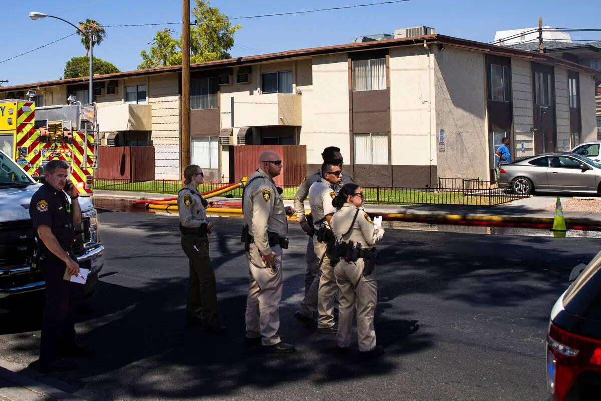 La policía de Las Vegas observa mientras los bomberos trabajan para contener un incendio en un ...