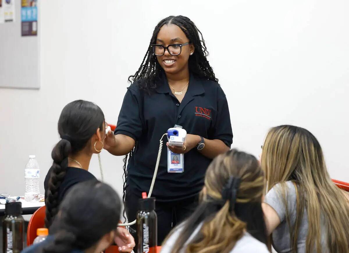 La estudiante de enfermería de la UNLV Hazel Krank, a la derecha, coloca un termómetro en la ...