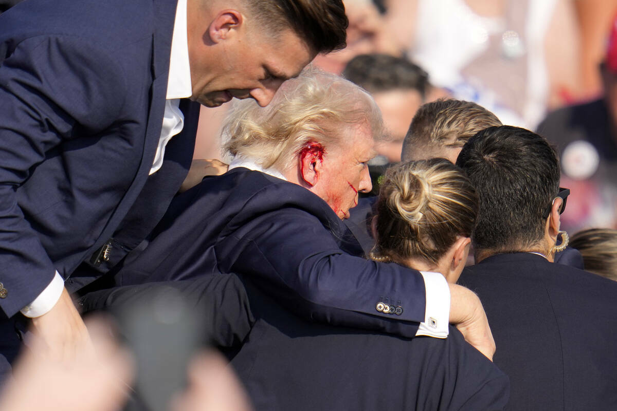 El candidato presidencial republicano, el expresidente Donald Trump, es ayudado a bajar del esc ...