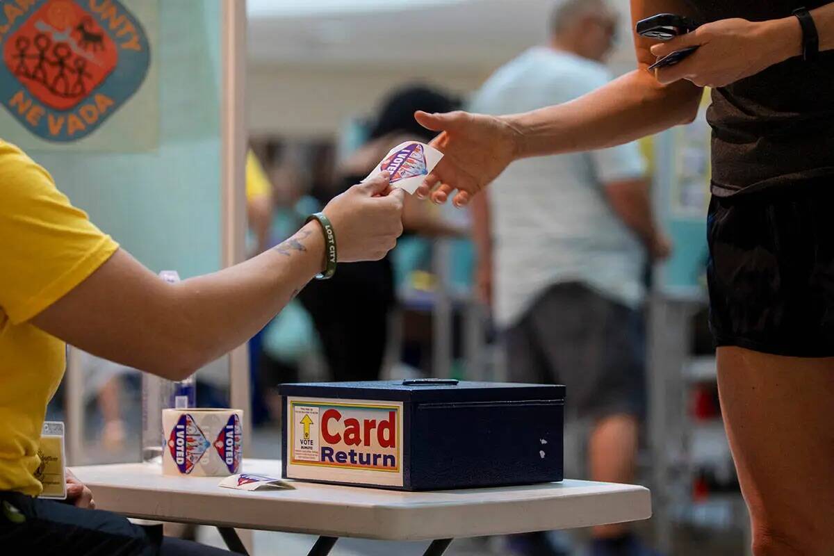 Un votante recibe una calcomanía de "Yo voté" después de emitir su voto durante las eleccion ...