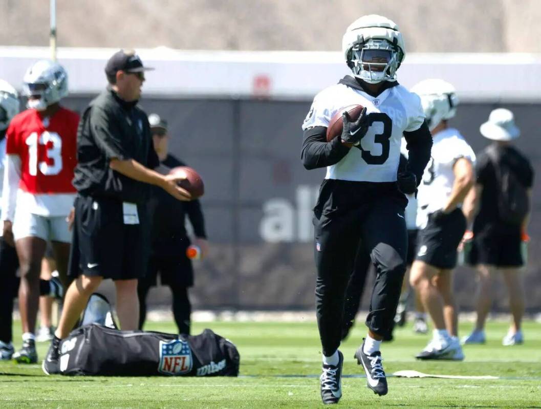 El running back de los Raiders Zamir White (3) realiza ejercicios de lanzamiento durante el ent ...