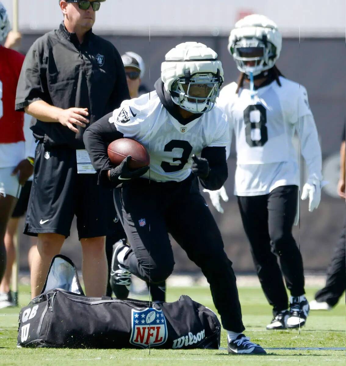 El running back de los Raiders Zamir White (3) realiza ejercicios de lanzamiento durante el ent ...