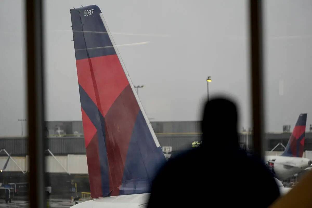 Un hombre mira por la ventanilla de un avión de Delta Airlines en el Aeropuerto Internacional ...