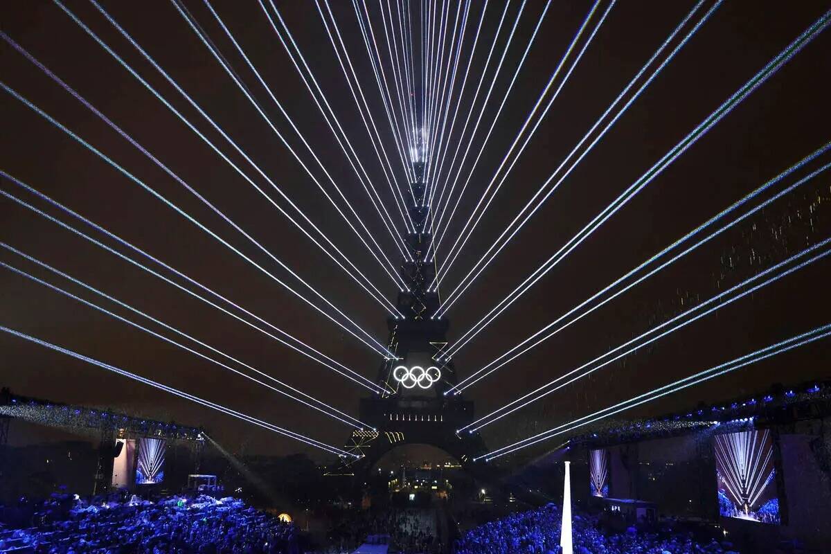 Luces iluminan la Torre Eiffel, en París, Francia, durante la ceremonia de apertura de los Jue ...