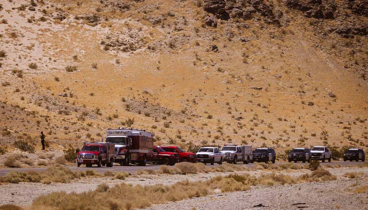 Vehículos de las fuerzas del orden se ven reunidos junto a la escena del incendio de un camió ...