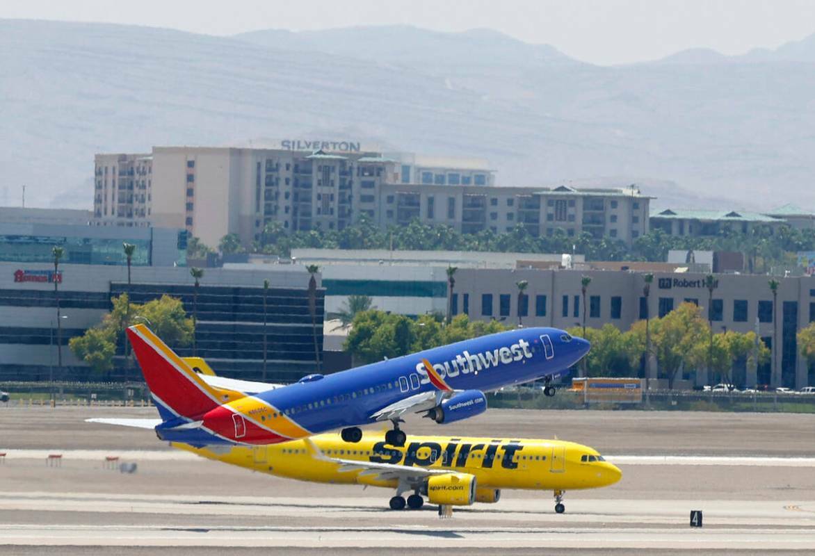 Un avión de Southwest Airlines despega mientras un avión de Spirit Airlines rueda sobre la pi ...