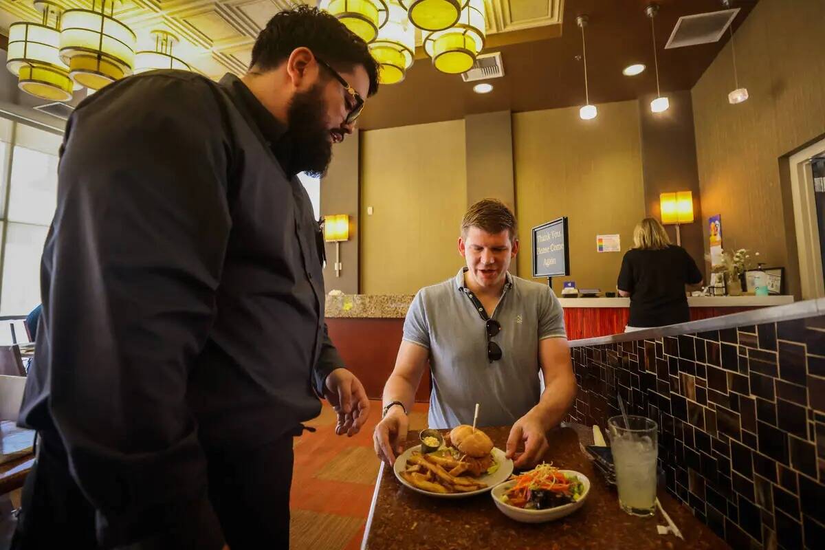 Pablo Partida, un estudiante, sirve a Jakob Bernhardt su almuerzo en el Westside Bistro de la C ...