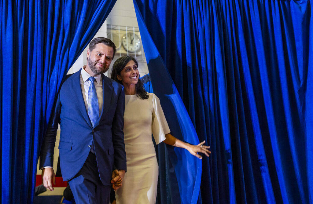 El senador de Ohio JD Vance y su esposa, Usha, observan desde las cortinas laterales mientras l ...