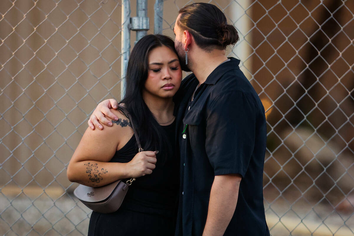 Dolientes se abrazan durante una vigilia por Kameron Moore y Vincent Herrera en Riverbend Villa ...