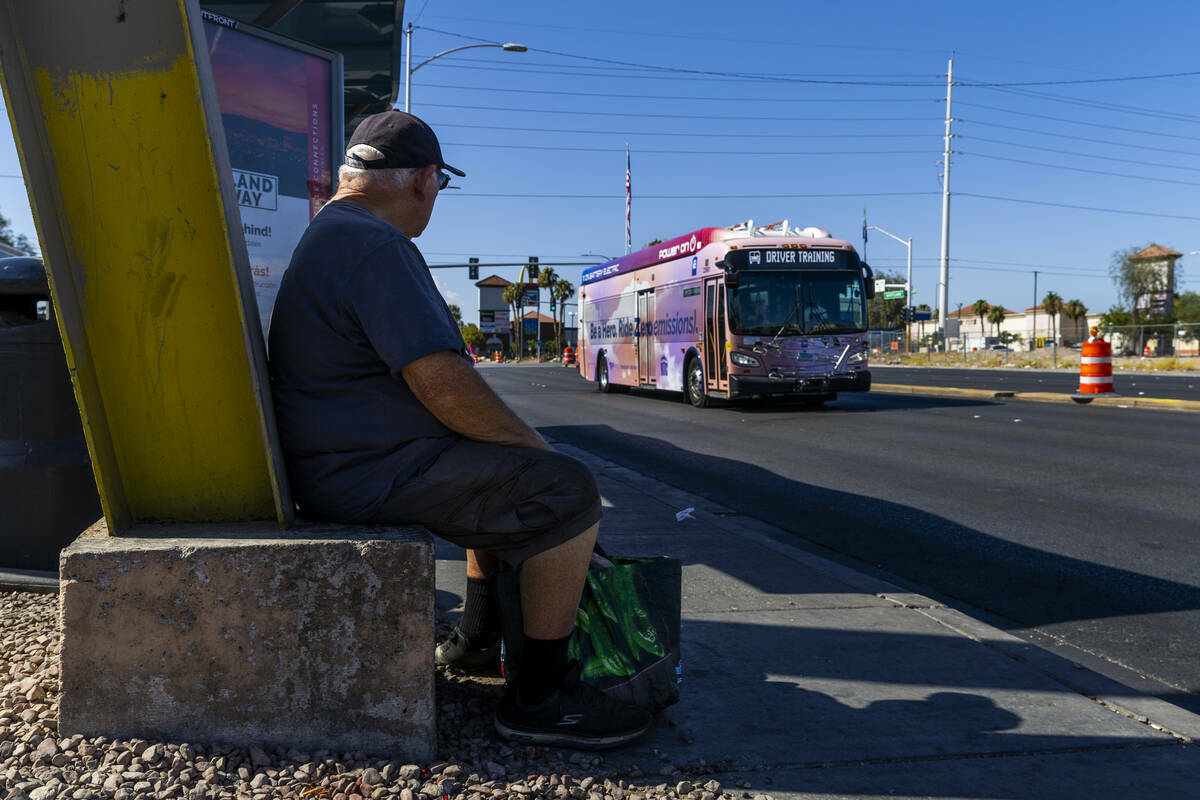 Un usuario observa un autobús que circula hacia el norte más allá de una parada a lo largo d ...