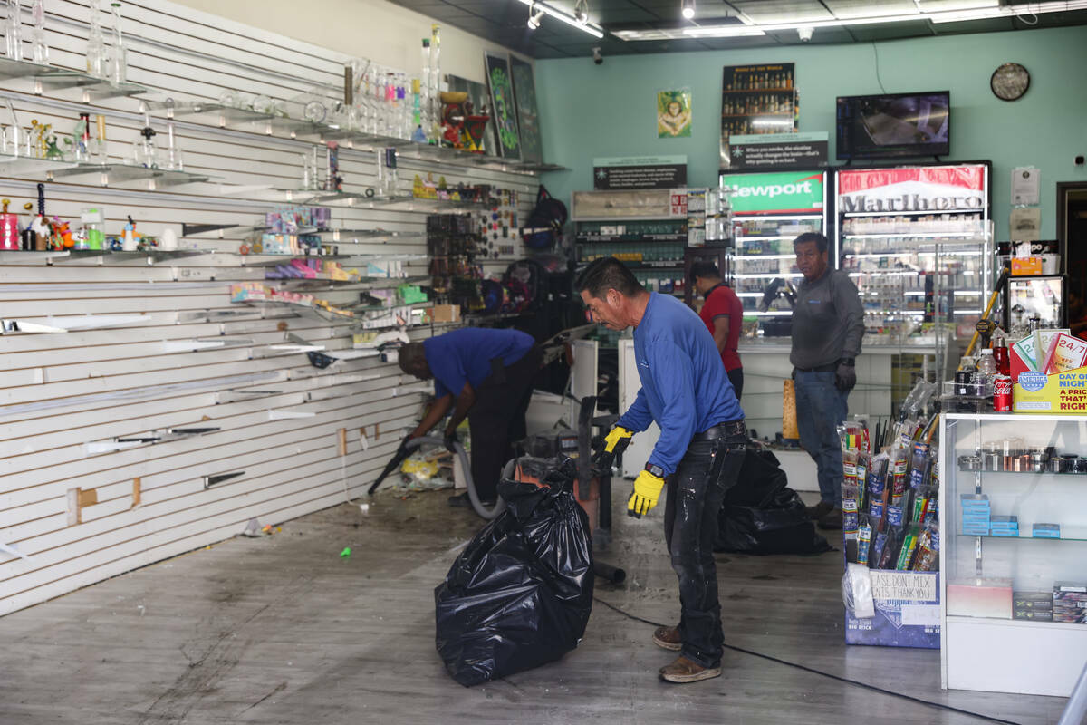 Trabajadores limpian los escombros en uno de los dos negocios en los que, al parecer, entraron ...