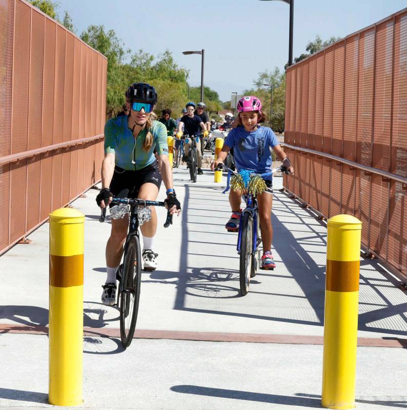 Ciclistas cruzan el nuevo puente peatonal y para bicicletas cerca de Gunderson Middle School de ...