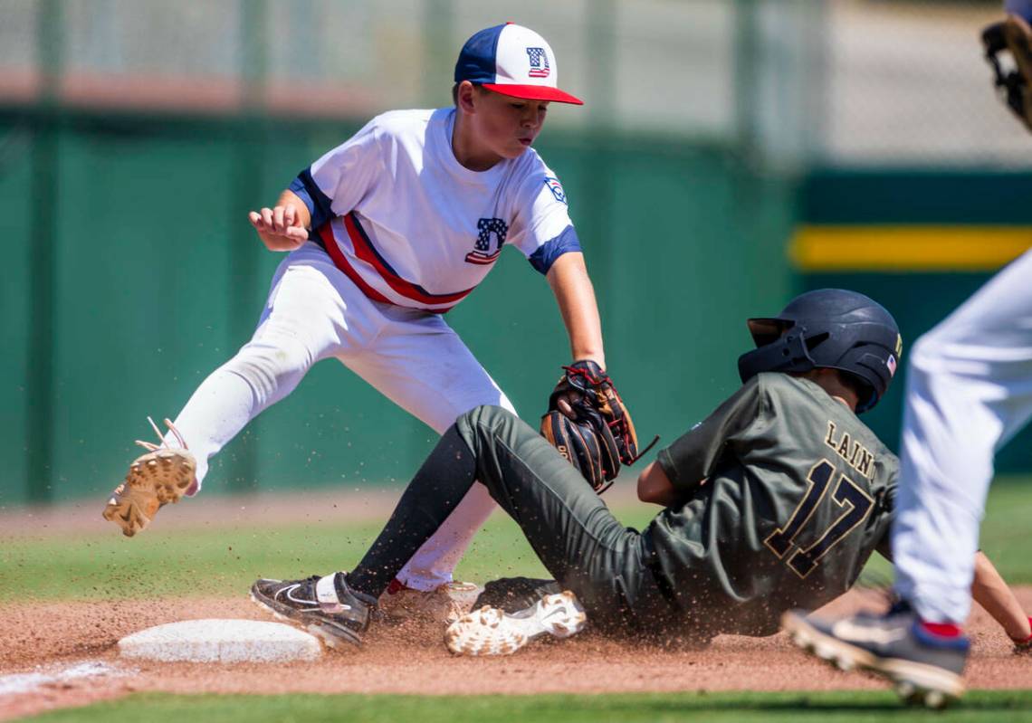 El base runner de Nevada Dominic Laino (17) se desliza a salvo en tercera base contra el infiel ...