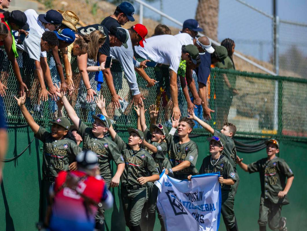 Jugadores de Nevada celebran en el campo con sus fans y la pancarta ganadora después de derrot ...