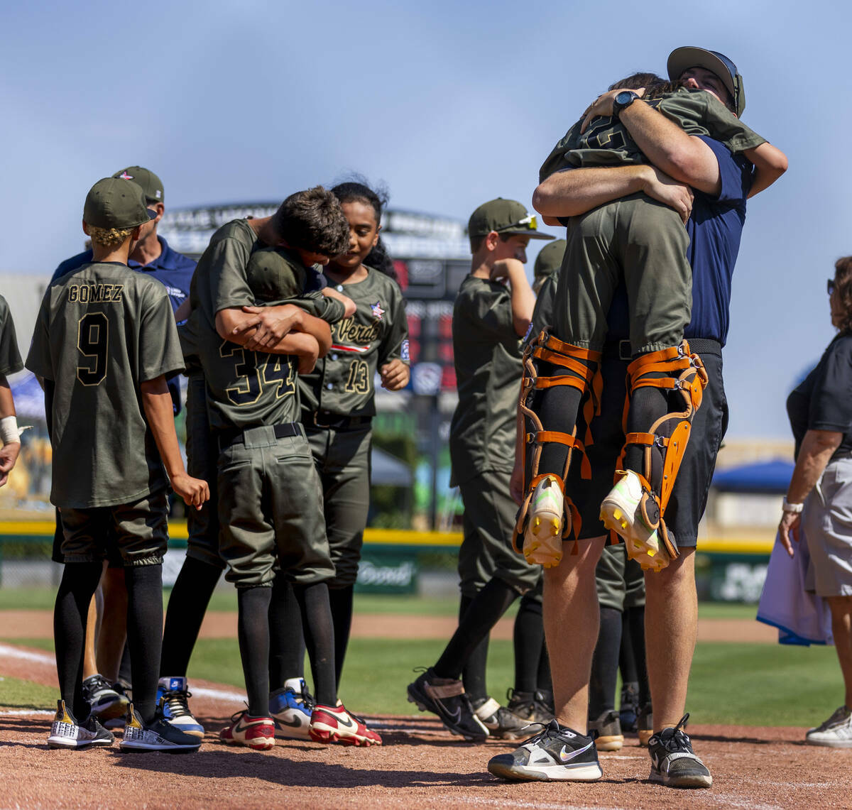 El entrenador de Nevada, Adam Johnson, abraza al catcher Parker Soranaka (23) mientras celebran ...