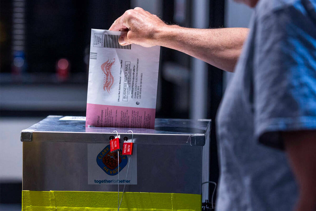 Un elector deposita su boleta de voto por correo durante la jornada de elecciones primarias de ...