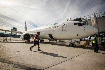 Una cuadrilla de tierra en el Aeropuerto Internacional Harry Reid prepara un WestJet para el de ...