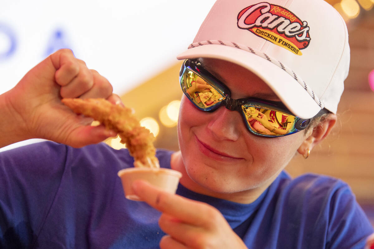 La medallista olímpica Katie Grimes moja una tira de pollo en salsa durante un ‘turno’ pro ...